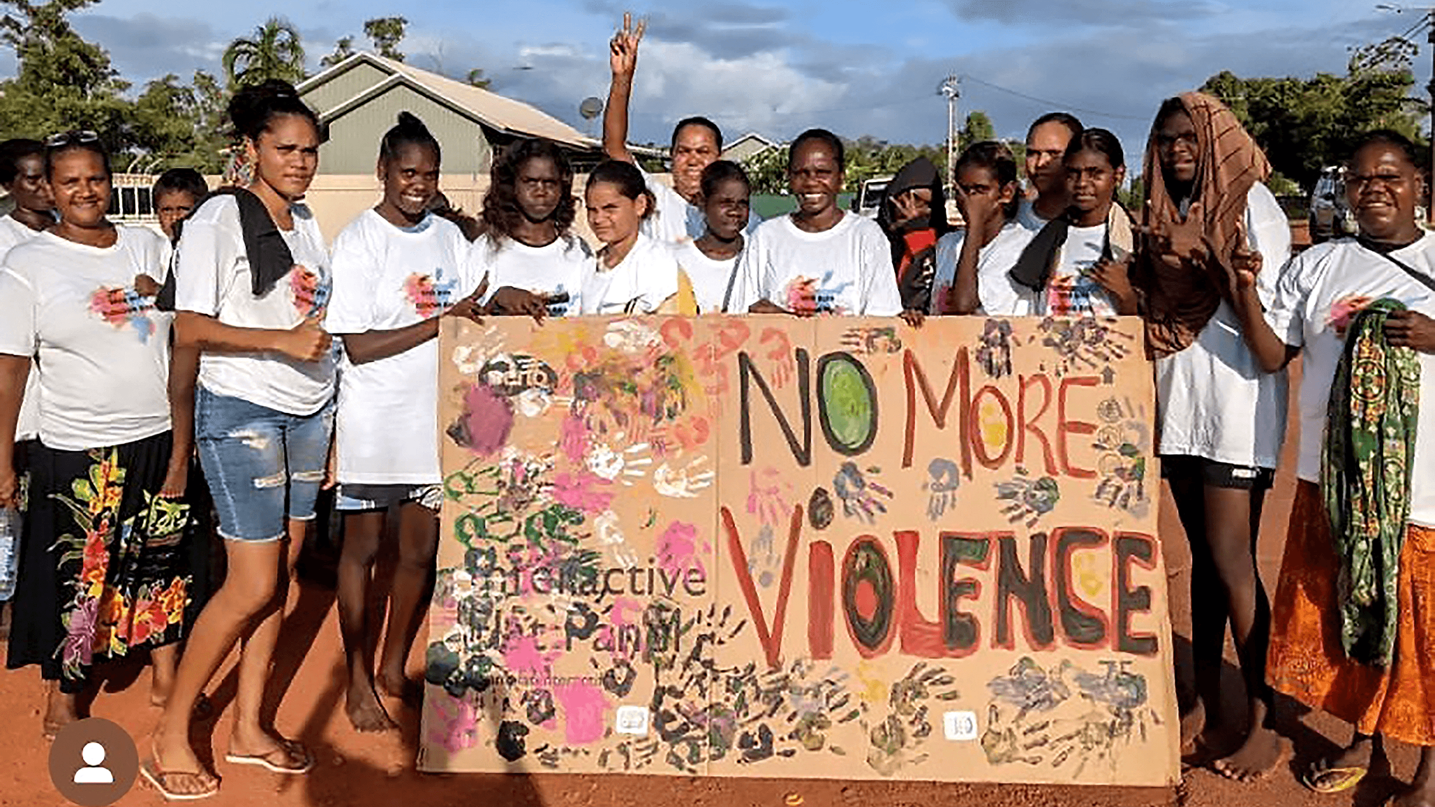 Large group hold sign with handle prints and a painted sign with "No More Violence"